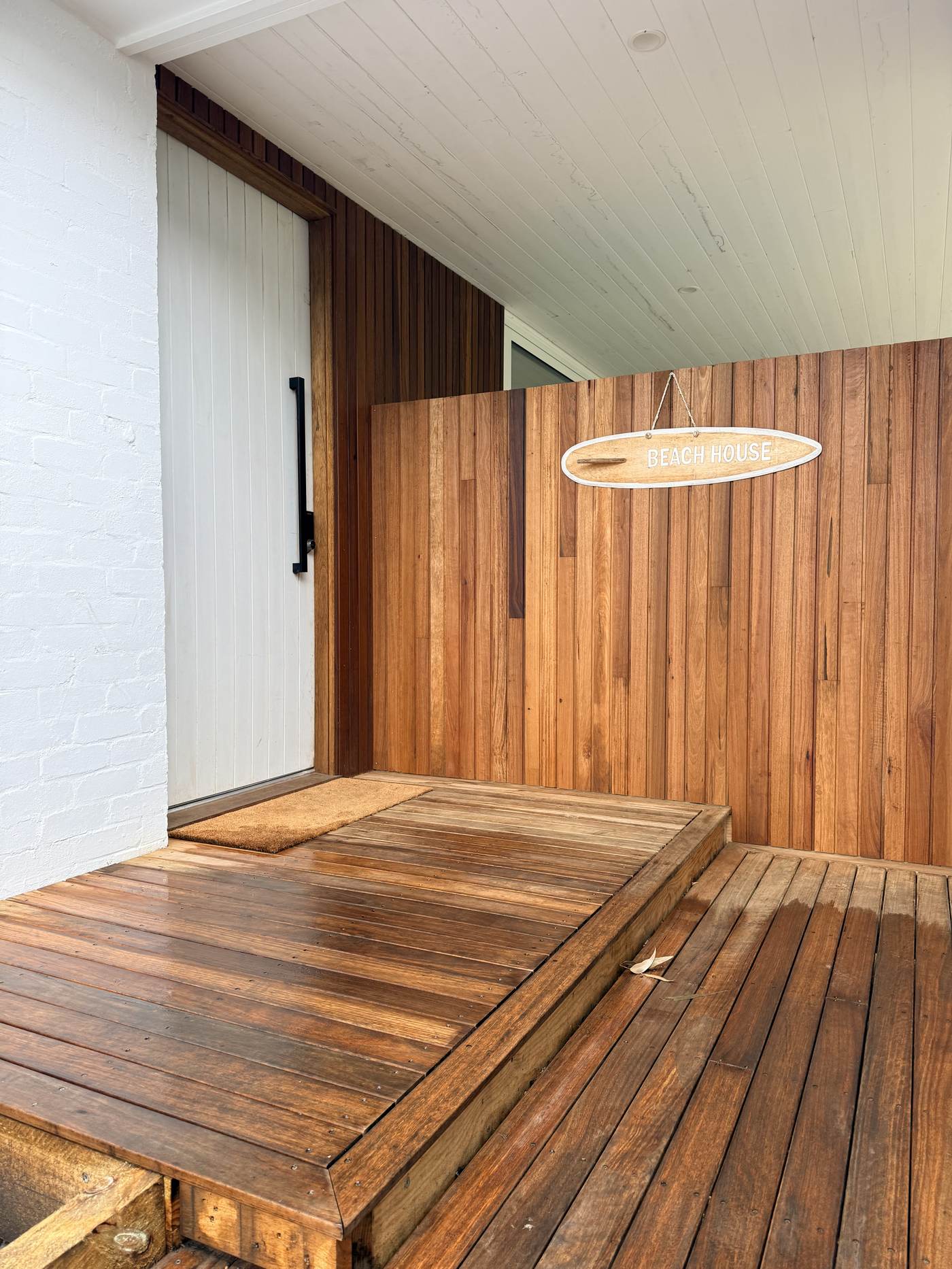 Timber-clad entry deck with Beach House sign